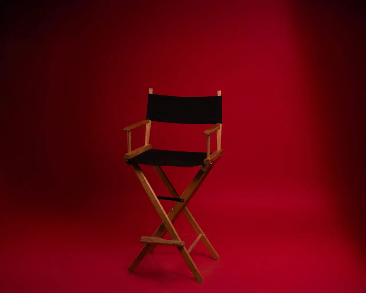 Silla de director de madera sobre un fondo rojo